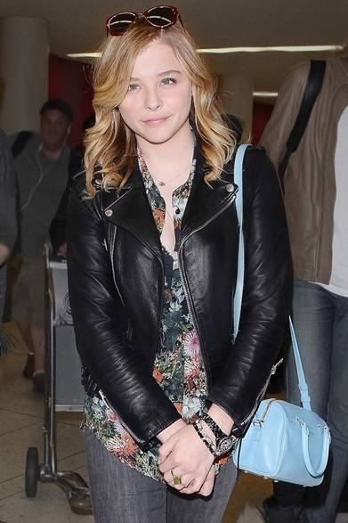 <strong>Chloe Moretz｜クロエ・モレッツ</strong><br /><br />ライダースジャケットに花柄のシャツを合わせた辛口のガーリースタイルに。ベビーブルーのサンローラン「BABY DUFFLE」が軽やかなアクセントを添える。<br /><br />Courtesy of SAINT LAURENT