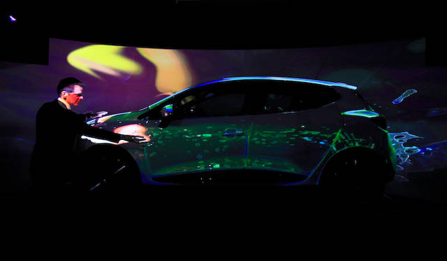 “触れる”プロジェクションマッピングのデモンストレーションをおこなうデュポン氏。手元の赤い光が触れた奇跡を描く