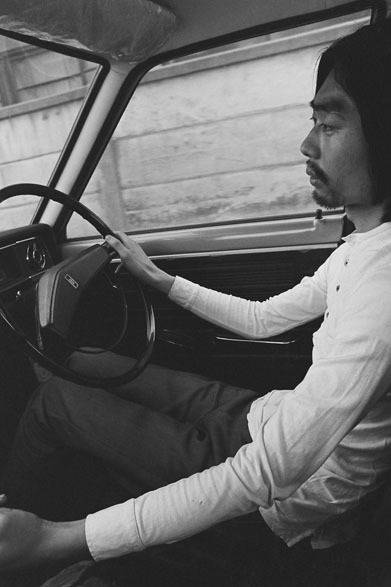 <strong>写真集アプリ「野上眞宏のSNAPSHOT DIARY」</strong>　1970年1月　「なんか面白いことがないかな」で始まった国道16号線ドライヴ。細野晴臣に電話して、アメリカっぽい国道16号線でも通って横浜の方へ行こうよと言った。細野はドライヴが好きだったし、ぼくは森山大道が『カメラ毎日』に当時発表していた国道16号線の写真を見ていたので、自動車の中から写真でも撮って遊ぼうと思った。 ぼくは撮影し、運転は細野だった。　© Mike Nogami