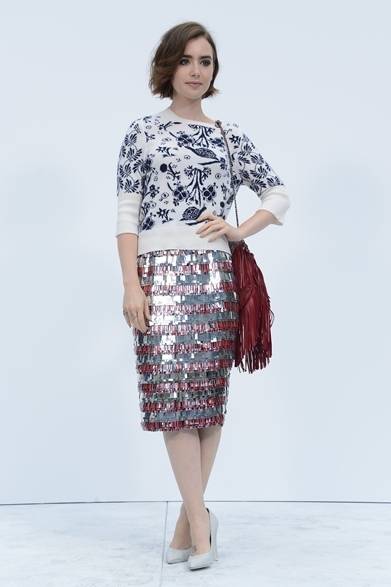 <strong>Lily Collins｜リリー・コリンズ</strong><br /><br />シャネルのショーに女優のリリー・コリンズも登場。ユニークなフラワープリントをほどこしたニットに、メタリックカラーのペンシルスカートを合わせて、異なる素材をミックスして個性に満ちたルックに。さらに、赤いフリンジバッグのチョイスが冒険心を見せてくれた。