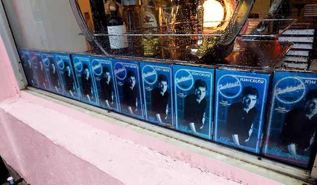 「BYOB カクテル・エンポリアム」。ピンクの壁が目を引く店の入り口には、トム・クルーズの主演映画『カクテル』のビデオパッケージがズラリ