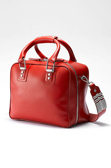 <strong>WOMENS｜</strong>ラウンドジップのデザインが目を引くボストンタイプのバッグ。ショルダーストラップの付け根にもメタルパーツをつけて、「ディーゼル ブラック ゴールド」らしいデザインに仕上げられている。[W28×H22×D13cm]、バッグ11万160円［DIESEL GINZA限定］（ディーゼル ブラック ゴールド）