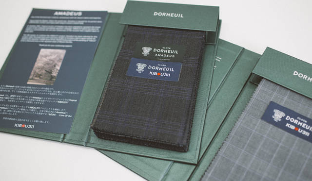 ドーメル社では、2012年春夏シーズンより服地「Amadeus」の収益の一部をルームニッポンに寄付している。生地には「KIBOU311」と書かれたタグがつく（Photograph by JAMANDFIX）