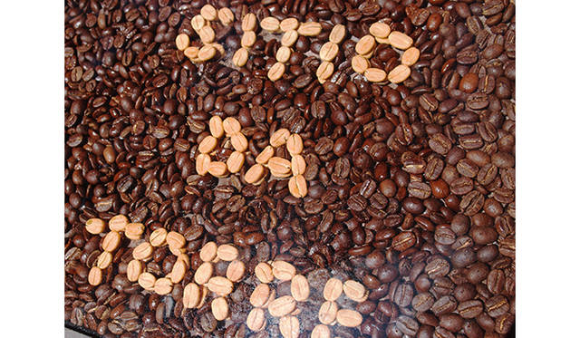 乾燥しただけのコーヒー豆とローストしたコーヒー豆でできた農園の看板