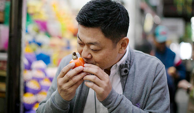 ブラジル特産のカシューの実を試す成澤シェフ