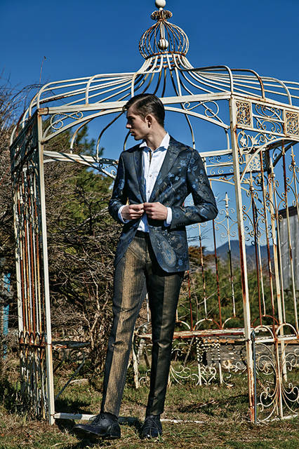 シルクジャカードのような滑らかなタッチのジャケットは、カルゼ調のコットンにネイビー×サックス×ブロンズゴールドでペイズリーとボタニカル柄を表現。光沢のあるパンツもブロンズゴールドなので、個性的なドレスアップスタイルを楽しめる。<br><br>ジャケット20万5200円、パンツ7万1280円、シャツ8万9640円(すべて阪急メンズ限定)、シューズ参考商品／エトロ〈阪急メンズ大阪3階〉〈阪急メンズ東京3階〉