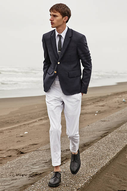 ラペルや裾などのディテールにフライドエッジ加工を施したジャケットは、アームホール高めでブランドのアイデンティティが漂うシルエット。春らしいシアサッカーのパンツはローライズで、サイドにはトリコロールテープの側章が入っている。 <br><br> ジャケット43万2000円(阪急メンズ限定)、パンツ13万3,920円(阪急メンズ先行販売)、シャツ3万7800円、タイ2万5920円、タイバー4万7520円、シューズ11万9880円／トム ブラウン ニューヨーク〈阪急メンズ大阪3階〉〈阪急メンズ東京3階〉