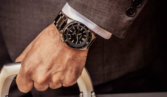 鉄板のビジネススタイルとも言えるグレースーツ。きっちりとした装いにも、トランスオーシャンはよく似合う。スーツ価格7万9920円(シップス銀座店Tel.03-3564-5547)、シャツ価格2万1600円／ギ ローバー、ネクタイ価格1万9440円／ルイジ ボレッリ（すべてシップス銀座店Tel.03-3564-5547）、カーディガン価格2万8080円／ルトロワ（八木通商Tel.03-6809-2183）、メガネ価格2万9160円／モスコット（モスコット トウキョウTel.03-6434-1070）、その他スタイリスト私物。