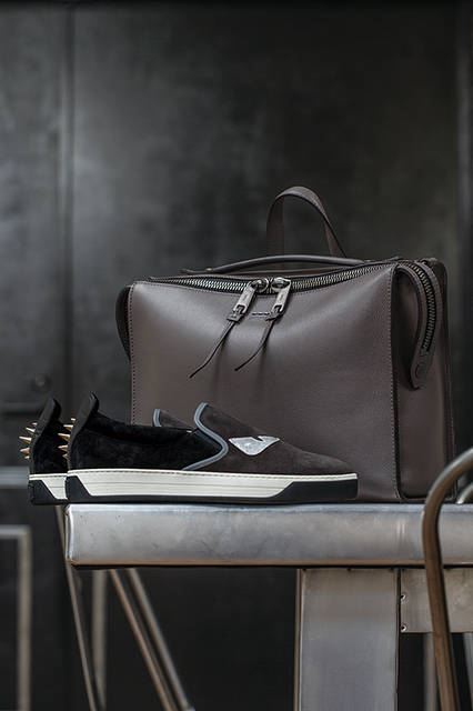 シンプルでクリーンなデザインに、ビッグジップやふたつのハンドルといった個性的な要素をミックスしたバッグは、機能性も抜群。モノトーンのスエード素材のシューズには、アイコニックな「バッグバグス」がフェンディらしい遊び心を添えている。<br><br>バッグ[W36×H27×D15cm]42万120円、シューズ10万440円／フェンディ〈阪急メンズ大阪3階〉〈阪急メンズ東京3階〉