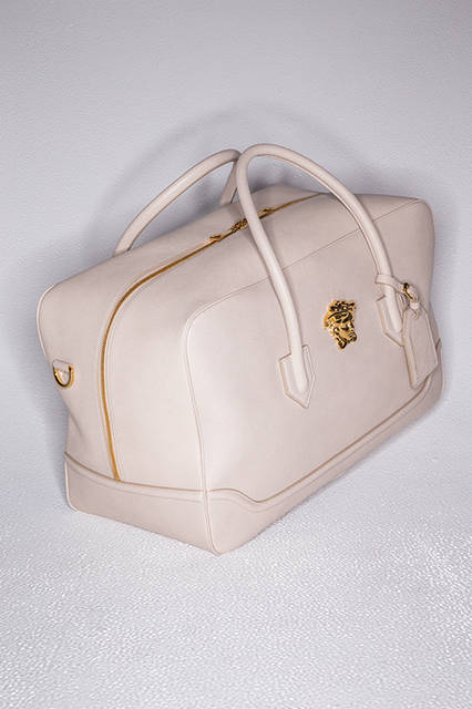 シーズンテーマである砂漠からインスパイアされたサンドベージュを配したバッグは、小旅行にちょうどいいボストンタイプ。フロントにはアイコンとしておなじみのゴールドカラーのメドゥーサが鎮座しており、個性、存在感ともに格別のインパクトを放つ。<br><br>バッグ[W48×H29×D22cm]37万5840円(阪急メンズ先行販売)／ヴェルサーチ〈阪急メンズ大阪3階〉〈阪急メンズ東京2階〉