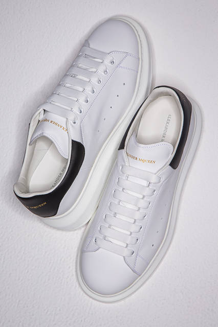 定番モデルのオーバーサイズドスニーカーは、シンプルなレースアップのデザインと丸みを帯びたラバーのラウンドトゥがポイント。ホワイトをベースにヒールにブラックをあしらったシンプルな配色ゆえ、スーツからカジュアルまで活用できる万能な一足だ。<br><br>シューズ7万4520円／アレキサンダー・マックイーン〈阪急メンズ大阪3階〉〈阪急メンズ東京2階〉