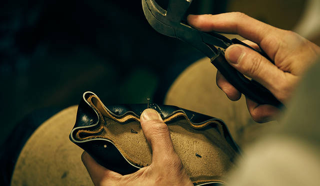 木型に縫い上がったアッパーをかぶせて固定する、釣り込みという作業。靴を立体的に仕上げるための重要な工程だ。既製靴の場合は機械を用い、均一な力で引っ張って固定するが、ビスポークでは随所で力を加減しながら固定するため、より美しく立体的なフォルムに仕上がる。