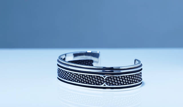 編み込み部分が持つしなやかさ、エッジ感を強く持たせた硬質さなど、相反する要素が融合したコンポジットシリーズのバングル。程よいサイズ感で、ひとつ着けはもちろん重ね着けにも対応する。<br /> <strong>「トラドバングル」</strong><br /> 価格10万円（税抜）