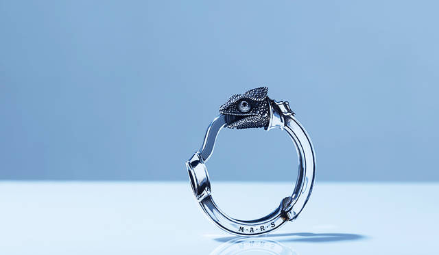 カメレオンの表情を繊細に表現したキーリング。両目のはガーネットをあしらっている。舌の部分が開閉するので、鍵の装着やウォレットチェーンのアタッチメントとして使用できる。<br /> <strong>「グリムカメレオンキーリング」</strong><br /> 価格6万5000円（税抜）