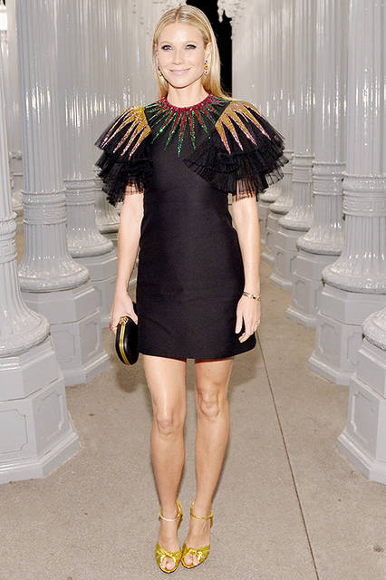 <strong>グウィネス・パルトロー</strong><br /> ドレス：2017年春夏コレクションのマルチカラースパンコール刺繍のチュールラッフル ショートスリーブが特徴的なブラックシルククレープ カクテルドレス<br /> バッグ：タイガーヘッドクロージャー付きブラックレザー クラッチ<br /> シューズ：ゴールドストラップ ハイヒールサンダル