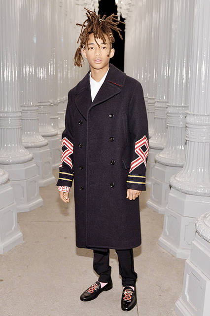 <strong>ジェイデン・スミス</strong><br /> ウェア：2017年クルーズ コレクションよりルック69のブラック ウール ダブルブレスト コート、 ホワイト イブニング シャツ、ブラック パンツ<br /> シューズ：スネーク パッチ付きのブラック レザー ローファー