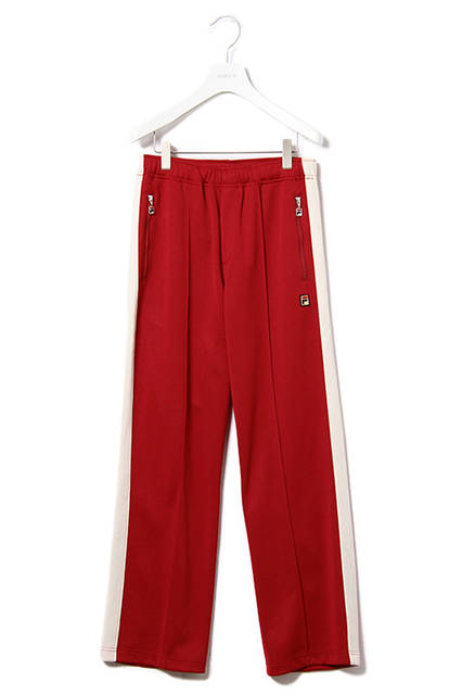 <strong>トラックスーツ</strong><br /> ポリエステルジャージ素材を使用したボリュームシルエットのスタンドカラーのジャケットと太目のストレートシルエットでリラックスムード漂うウエストゴムパンツの組み合わせ。）<br /> ベースカラーは渾身のレッドワンカラーのみで、ビンテージライクな色と質感を表現した。ジャケットに施されているトーンオントーンの切り替えは、テニスプレーヤーGuillermo Vilas（ギリェルモ・ビラス）のシグネチャーモデルに採用されていたラインをデザイン化したもの。）<br /> トラックスーツジャケット｜2万2000円（税別））<br /> トラックスーツパンツ｜1万4000円（税別））<br />