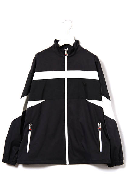 <strong>ウインドアップスーツ</strong><br /> コットンナイロンのストレッチ素材を使用した、ボリュームシルエットのスタンドカラージャケットと裾にゴムシャーリングを施したトラックパンツの組み合わせ。<br />  カラーは都会的なライトカーキとダークネイビー。パンツのサイドラインの柄はテニスプレーヤーであるBjon Borg（ビヨン・ボルグ）のシグネチャーモデルに採用されていたリブの柄にインスパイアされている。<br />  ウインドアップジャケット｜2万8000円（税別）<br />  ウインドアップパンツ｜1万8000円（税別）<br />