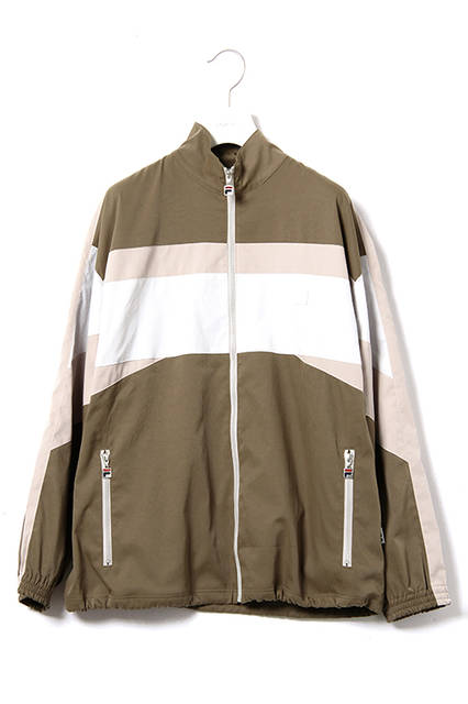 <strong>ウインドアップスーツ</strong><br /> コットンナイロンのストレッチ素材を使用した、ボリュームシルエットのスタンドカラージャケットと裾にゴムシャーリングを施したトラックパンツの組み合わせ。<br />  カラーは都会的なライトカーキとダークネイビー。パンツのサイドラインの柄はテニスプレーヤーであるBjon Borg（ビヨン・ボルグ）のシグネチャーモデルに採用されていたリブの柄にインスパイアされている。<br />  ウインドアップジャケット｜2万8000円（税別）<br />  ウインドアップパンツ｜1万8000円（税別）<br />