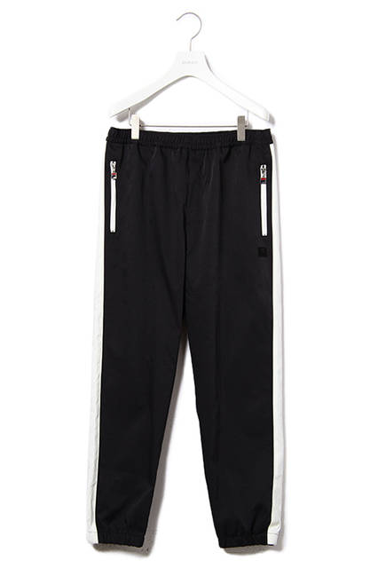 <strong>ウインドアップスーツ</strong><br /> コットンナイロンのストレッチ素材を使用した、ボリュームシルエットのスタンドカラージャケットと裾にゴムシャーリングを施したトラックパンツの組み合わせ。<br />  カラーは都会的なライトカーキとダークネイビー。パンツのサイドラインの柄はテニスプレーヤーであるBjon Borg（ビヨン・ボルグ）のシグネチャーモデルに採用されていたリブの柄にインスパイアされている。<br />  ウインドアップジャケット｜2万8000円（税別）<br />  ウインドアップパンツ｜1万8000円（税別）<br />