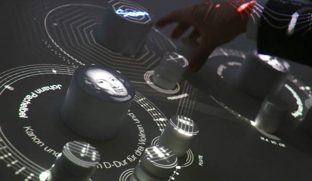 ソニー。オープンイノヴェーションによる開発プログラム「Future Lab Program」の参考展示。テーブル上部に高低差や手指の三次元的動きを認識するプロジェクタが備えられており、積み木を重ねることによって再生される楽器が増えてゆく。