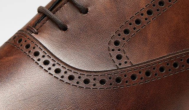 一見伝統的な穴飾りに見える装飾は、すべて革を貫通するホールと表面のみを削るステッチ状の2種類のレーザー加工で施されている。パーツを切り替える必要がないため、ホールカットの快適さを損なうことなく、クラシックなデザインを楽しめる革新的な手法だ。