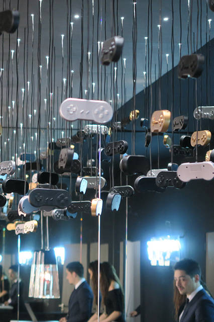 ロマン・ジェロームブースの天井に吊るされた大量のコントローラー。ファミコン世代には、非常にナツい。