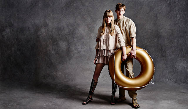 「メンズは、前身頃がシャツ地で後ろがジャージーになった異素材ミックスのプルオーバー。どことなく医師がオペ中に着ている術衣のよう。同系色のベージュのワークパンツにグラディエーターサンダルで軽やかに。ウィメンズはシャツ感覚で着られるスウェードのレースアップブルゾンに、ラッフルがあしらわれたミニスカート。こちらも足元はグラディエーターサンダルでリンクさせました」（左）レザージャケット15万5000円、レザースカート12万6000円、シューズ11万3000円（すべてディーゼル ブラック ゴールド）（右）プルオーバーシャツ2万8000円、パンツ3万6000円、サンダル6万8000円（すべてディーゼル ブラック ゴールド）