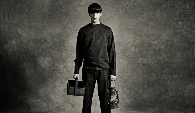 「キャンプ場の見回りバイト君です。ネイビーと赤のプリントTの上にプルオーバーをレイヤードして、一部ウェストイン。ボトムスはリジッドを選んで。着こなしが難しいといわれるネイビーのワントーンも、トーンを変えたり差し色を使ってアクセントをつけることで上級者の着こなしに」プルオーバーシャツ2万8000円、Tシャツ1万2800円、デニムパンツ2万7000円（すべてディーゼル ブラック ゴールド）