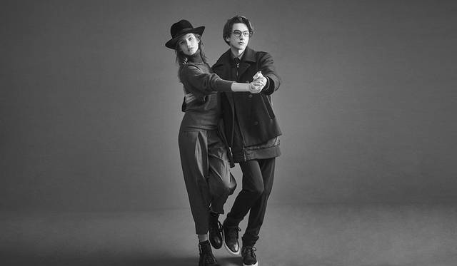 「グレーのタートルセーターにガウチョパンツのクリーンなスタイリングはボリューム感がカギ。ハットとブーツでマニッシュに。メンズは、ブルゾンとピーコートがドッキングしたようなジャケットを主役に、インナーはシャツ＆スラックスとドレスなムードに仕上げました」（左）ニット3万9000円、パンツ3万7000円、ブーツ7万5000円（以上ディーゼル ブラック ゴールド）その他スタイリスト私物（右）シャツ2万6000円、ジャケット10万8000円、パンツ3万4000円、スニーカー5万4000円（以上ディーゼル ブラック ゴールド）、その他スタイリスト私物