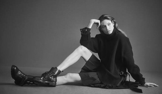 「たっぷりとしたニットのタートルネックにシャツのスリーブとプリーツスカートがドッキングしたワンピースは、サイドに付いたストラップでシルエットが調整可能。ハードなブーツを合わせてマニッシュに」ドレス7万9000円、ブーツ7万5000円（以上ディーゼル ブラック ゴールド）