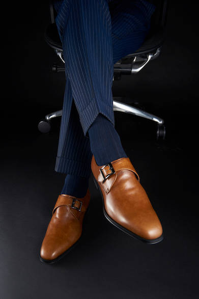 <strong>12PR</strong><br>25,000円（税別）<br>春らしい明るめのブラウンカラーが映えるビジネスシューズ。モンクストラップはスマートで知的な印象を与える。ダークネイビーのパンツに合わせ、若々しく活動的な印象に。