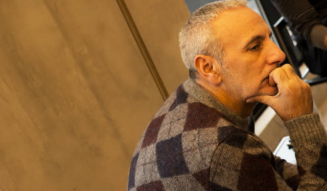 インタビューに答えるアレッサンドロ・デラクア。クラシカルなアーガイルのニットが目を奪う