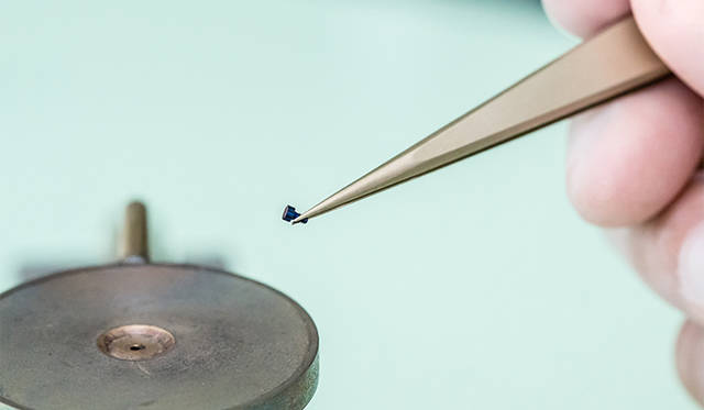 焼いたねじの色をチェック中。焼きムラができないように、時々向きを変えていく。