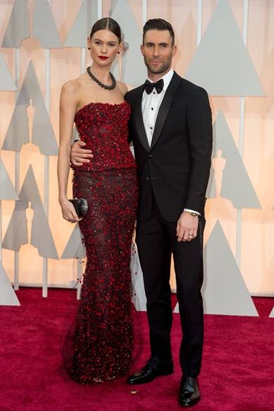 <strong>（左より）Behati Prinsloo   & Adam Levine｜ベハティ・プリンスルー＆アダム・レヴィーン</strong></br></br>パフォーマーを務めるマルーン5のアダム・レヴィーンは、スーパーモデルの妻ベハティ・プリンスルーとレッドカーペットに登場。</br></br>ベハティ・プリンスルー</br>ドレス：アルマーニ プリヴェ</br></br>アダム・レヴィーン</br>タキシード：ジョルジオ アルマーニ