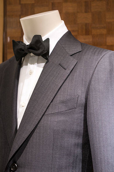 <strong>DUNHILL｜ダンヒル</strong><br><br>ブランドのイメージをしっかり反映したスタイルは、ヘリンボーンにストライプの織りが入って、ブラックながら表情豊かな質感を醸し出している。カジュアルパーティにも着られるスーツとして活躍間違いなし。スーツ42万8760円、シャツ5万7240円、ボウタイ1万9440円