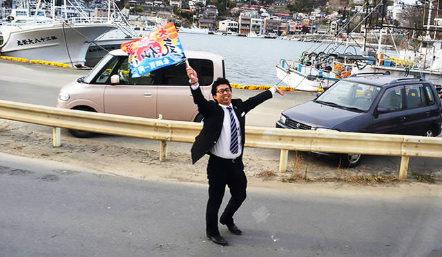 大漁旗を手にするスタッフに車内からは「さようならー」の声