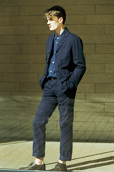 <strong>MARGARET HOWELL｜マーガレット・ハウエル</strong><br />コレクションにも登場したMHL.のジャケットはトラウザーズとセットアップで着用でき、ここではインディゴ調のリネンのシャツとコーディネート。ジャケットはボックスシルエットのワークウェア風で、タフな印象をあたえるのが新鮮だ。ジャケット 4万3200円、トラウザーズ 2万5920円、シューズ 5万1840円（すべてMHL.）、シャツ 3万2400円(マーガレット・ハウエル)