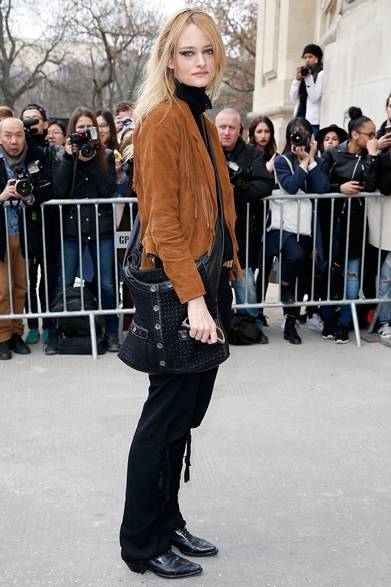 <strong>Nadine Strittmatter｜ナディーン・シュトリットマター</strong><br/><br/>シャネルのショー会場でキャッチしたモデルのナディーン・シュトリットマター。フリンジ付きのスエードジャケットとゆるめのテーラードパンツを合わせ、「ガール シャネル」を斜め掛して、ガーリーなウエスタンルックが完成。<br/><br/>© CHANEL