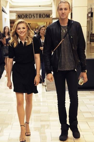 バージニア州のショッピングモールで買い物中のクロエ・モレッツ。サンローランのスクールガールドレスを着こなし、華奢な小物をコーディネイトに取り入れて清楚な印象に。無造作なウェーブヘアとスウィートな笑顔がキュート！COURTESY OF SAINT LAURENT 