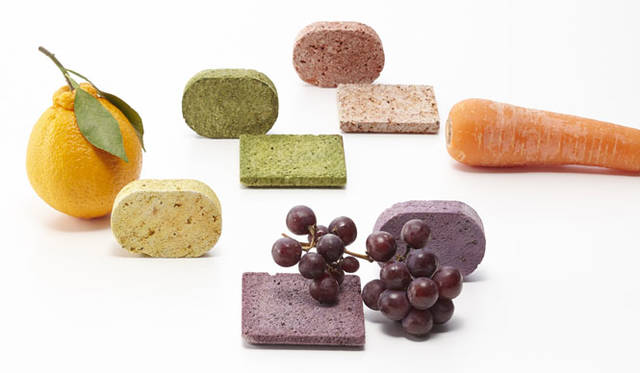<strong>ミラノサローネ2015｜Experimental Creations</strong><br/>＜Material Experiments＞<br />秋山かおり（STUDIO BYCOLOR）「STONE COMPOTE」<br />“日本では年間1800万トンの食品廃棄物が排出されている。その背景から、野菜・果物の「皮」に注目。野菜や果物の皮と、石と水分をともにコンポート（煮る）し、十分な乾燥をほどこし、皮の色素を石へと移行させた。表面はまるでサブレのようなおいしそうなテクスチャに仕上がった。軽石とソープディッシュとして展開