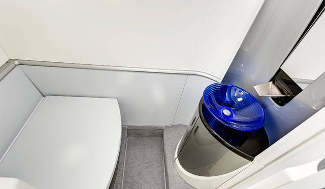 ブルーのガラスの洗面ボウルは自慢のしつらえ。天窓からの明るい光に合うように選ばれた