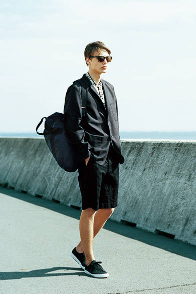 <strong>MARGARET HOWELL｜マーガレット・ハウエル</strong><br />パッチポケットがカジュアルな雰囲気を演出するジャケットは、マーガレット・ハウエルで人気の高いフォックスブラザーズ社製のサマーウール素材を使用。軽くしなやかに着こなせるのがうれしい。大きめのチェックのリネンシャツに、織りで深みを感じさせるショーツを合わせて、ワントーンですっきりと。<br />ジャケット6万8040円、シャツ2万9160円、ショーツ2万7000円、バッグ2万8080円、サングラス7万3440円（店舗限定）、スニーカー2万2680円（すべてマーガレット・ハウエル）