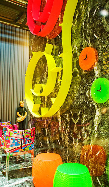 ブックシェルフ「POPWORM」by Ron Arad、チェア「MADAME – World of Emilio Pucci edition 」by Philip Stark、時計「CRYSTAL PALACE」by Alessandro Mendini、スツール「ROY」by Alessandro Mendini<br>フィリップ・スタルクの「MADAME – World of Emilio Pucci edition」は、パリ、ローマ、ニューヨーク、上海の都市に着想を得た４種のカラー・テキスタイルを使ったチェアだ