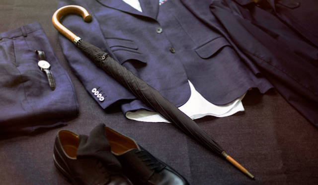 写真2から4で紹介する傘 3万240円（フォックス・アンブレラ／ヴァルカナイズ・ロンドン Tel. 03-5464-5255）、ステンカラーコート 12万9600円（マッキントッシュ／マッキントッシュ青山店 Tel. 03-6418-5711）、リネンのテーラードジャケット 25万560円、シャツ 4万1040円、リネンのスラックス 7万200円、ポケットチーフ 1万2960円、腕時計 70万2000円（以上、すべてダンヒル／リシュモン ジャパン Tel.03-4335-1755）、ソックス 3564円（パンセレラ／リーミルズ エージェンシー Tel. 03-3473-7007）、靴 11万8800円（ジェイエムウエストン／ジェイエムウエストン青山店 Tel. 03-6805-1691）