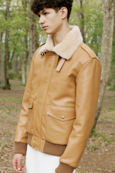 ミリタリーながらもモードテーストが凝縮されたアビエータージャケットは、上質なラムレザー(ナパ)とシアリングが醸し出すラグジュアリーな雰囲気に満ちたアイテム。ブルーとブラックのサイドラインが入ったフレアシルエットのジャージーパンツを合わせて、ノーブルなイメージに。 <br><br>  ジャケット86万2920円、パンツ14万400円／ロエベ<阪急メンズ大阪3階>