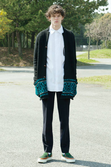 凹凸感が素朴な雰囲気のニットジャケットは、裾にビビッドなブルーで編み込まれたネイティブモチーフが目を惹く。ブロードの白シャツで上品さを、そしてセンタープリーツが入ったパンツを合わせてエレガントなイメージを着こなしに取り入れて。 <br><br>ニットジャケット6万5880円、シャツ2万8080円、パンツ3万9960円、シューズ6万2640円／カラー<阪急メンズ大阪2階『ガラージュ D.エディット』>