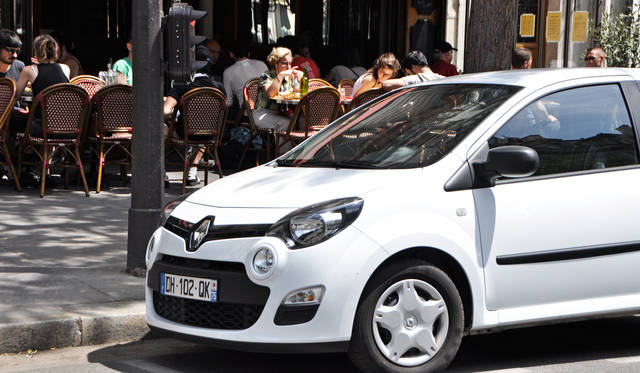 カフェのテラス、路上駐車のクルマ、低い位置のレトロデザインの信号機などパリの街になくてはならない