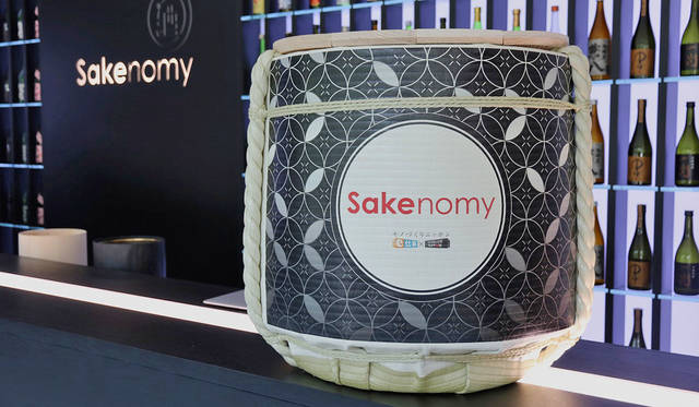 <strong>SAKENOMY｜サケノミー</strong><br />「SAKENOMY」開催にあわせて、店舗の看板に“酒樽”を使用。酒樽中央の「SAKENOMY」の文字は、今回のテーマでもある「塗り」にフォーカスし、日本古来より重宝されてきた「漆」で塗られている。ロゴを塗ったのは、一般より塗りをテーマに「塗師」として募集した研修生によるもので、蒔絵の人間国宝である室瀬和美氏の手ほどきを受けながら完成させた