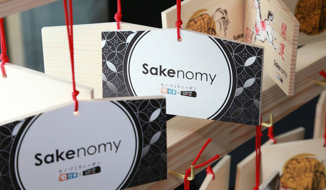 <strong>SAKENOMY｜サケノミー</strong><br />SAKENOMY内には「絵馬」を書くスペースを設置。 日本で塗りを学んだ塗師スタッフたちが日本の伝統的な「絵馬」に、SAKNOMYに来場されたゲストの“願い”を書くことを塗りの技術をもってサポート。完成された絵馬は、後日、下賀茂神社に奉納される